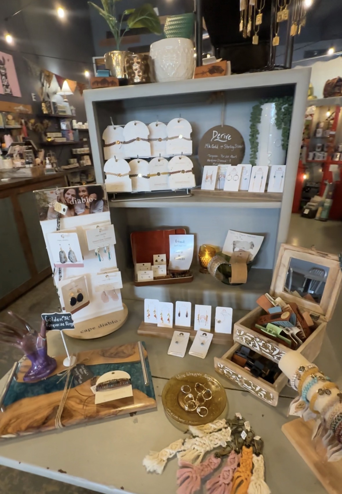 Jewelry and gift display with plants and small local items inside Avery Joes Boutique.