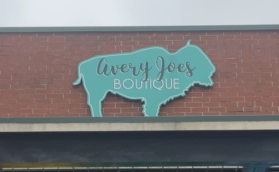 Avery Joes Boutique storefront sign on a brick wall in Yukon, Oklahoma.