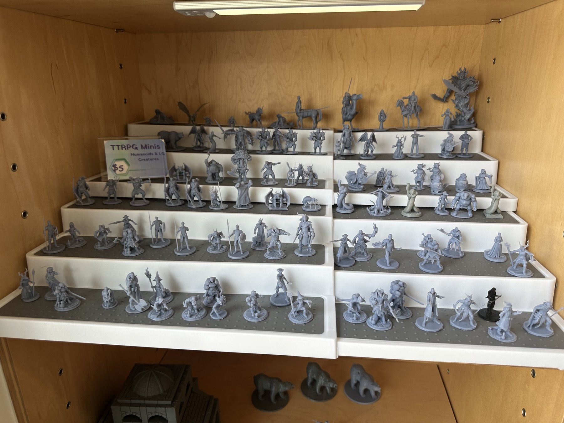 Tabletop RPG miniatures displayed on shelves at Side Quest Game Lounge in Oklahoma City