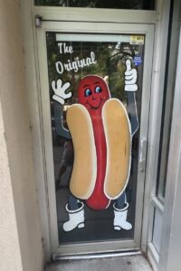 Cartoon hot dog mascot painted on the entrance door at Coney Island Downtown OKC.