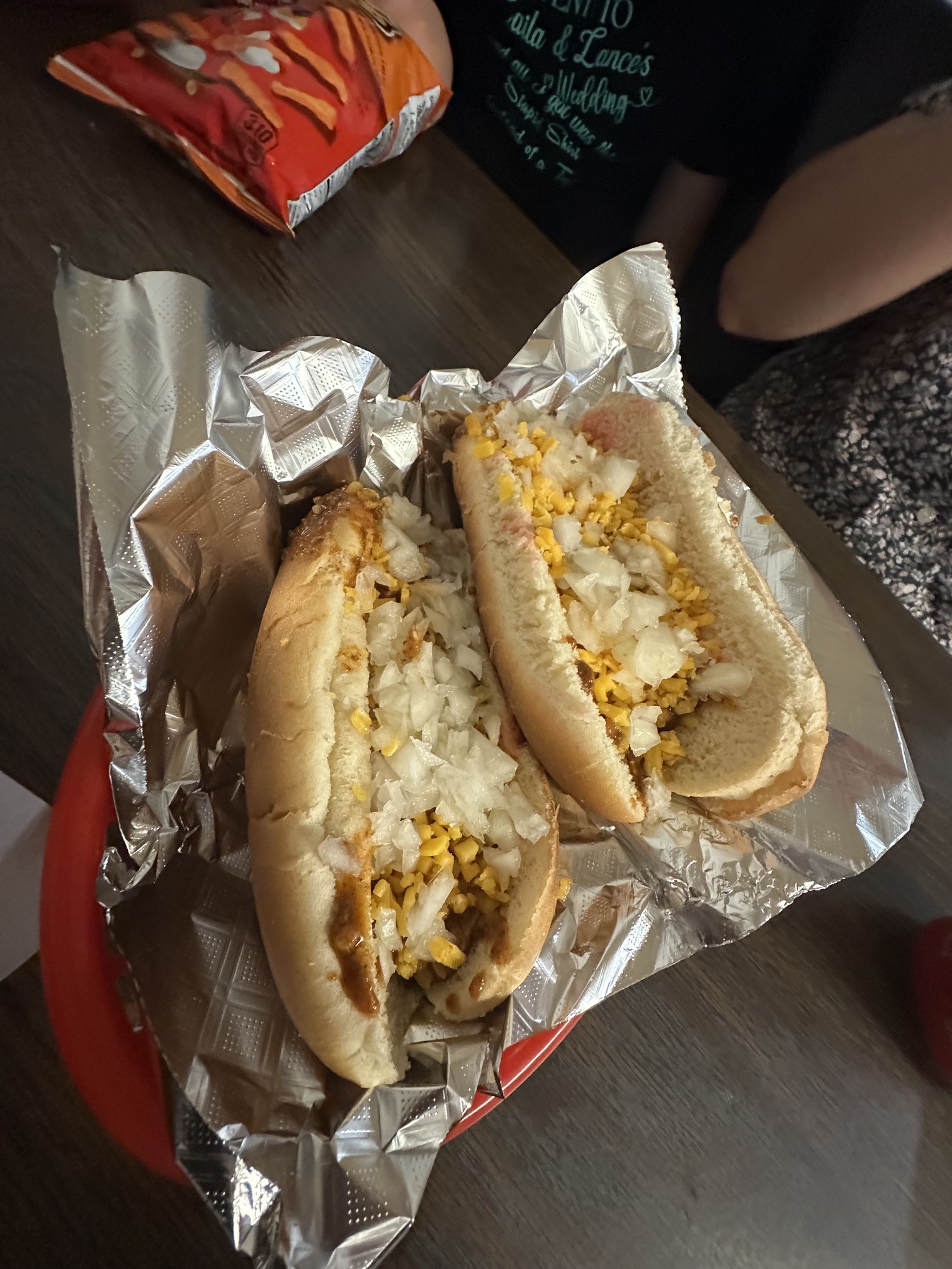Two chili cheese coneys with onions served in a foil-lined basket at Coney Island Downtown OKC.