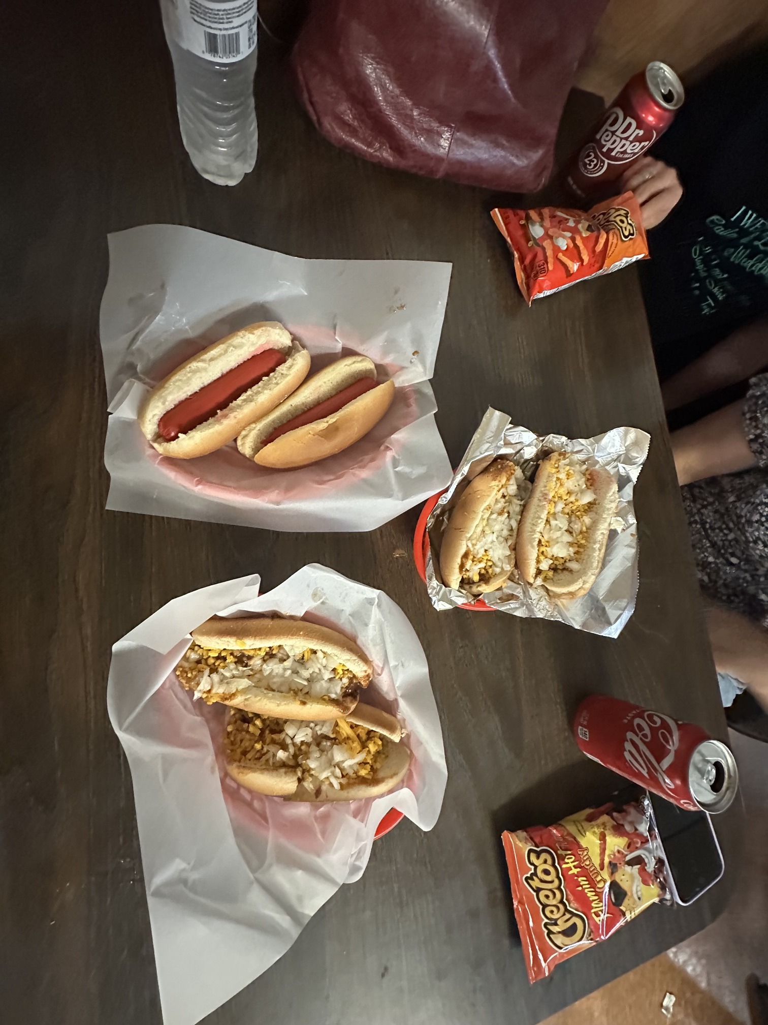 Table spread of hot dogs, chili cheese coneys, chips, and sodas at Coney Island Downtown OKC.