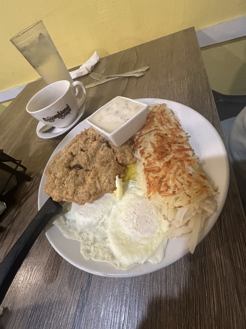 Country breakfast plate with chicken fried steak, eggs, hash browns, and gravy at Eggceptional Cafe in Oklahoma City.