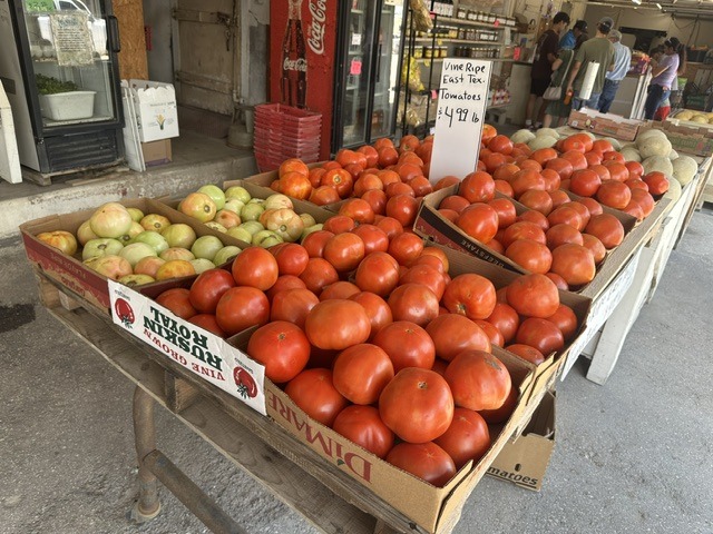 Large display of vine-ripe East Texas tomatoes for sale at Pinata Store near the OKC Farmers Market
