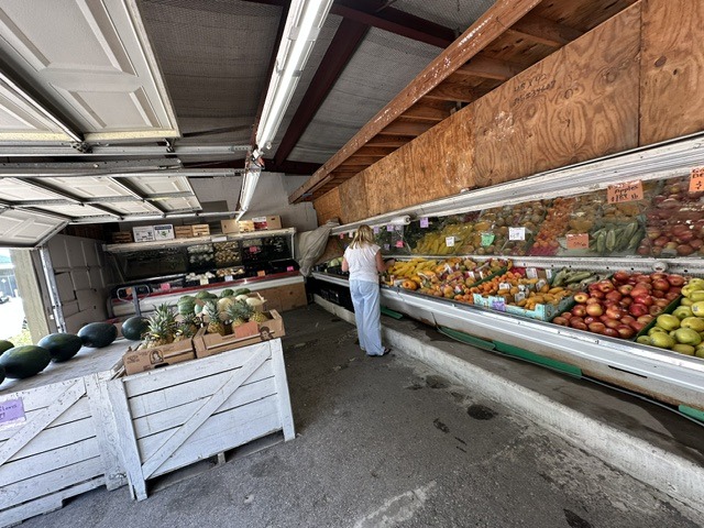 Interior of Pinata Store with long produce displays, fruit bins, and a shopper browsing