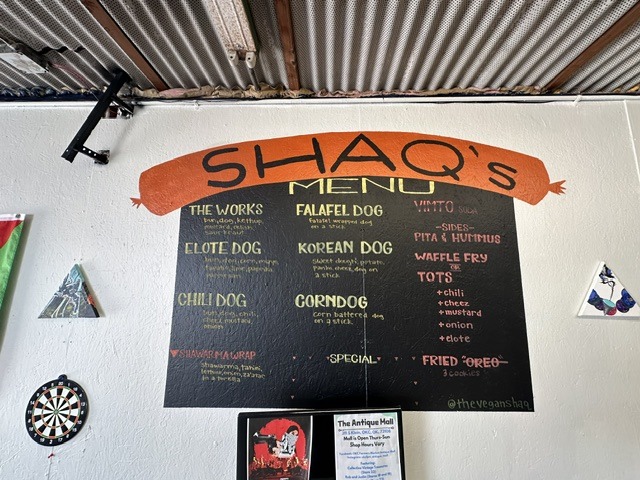 Menu board at Shaq’s Vegan Dogs in Oklahoma City listing vegan dogs, sides, tots, and fried Oreos