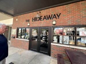 Front entrance of The Hideaway Pizza in Stillwater, Oklahoma, with the sign on a brick building.