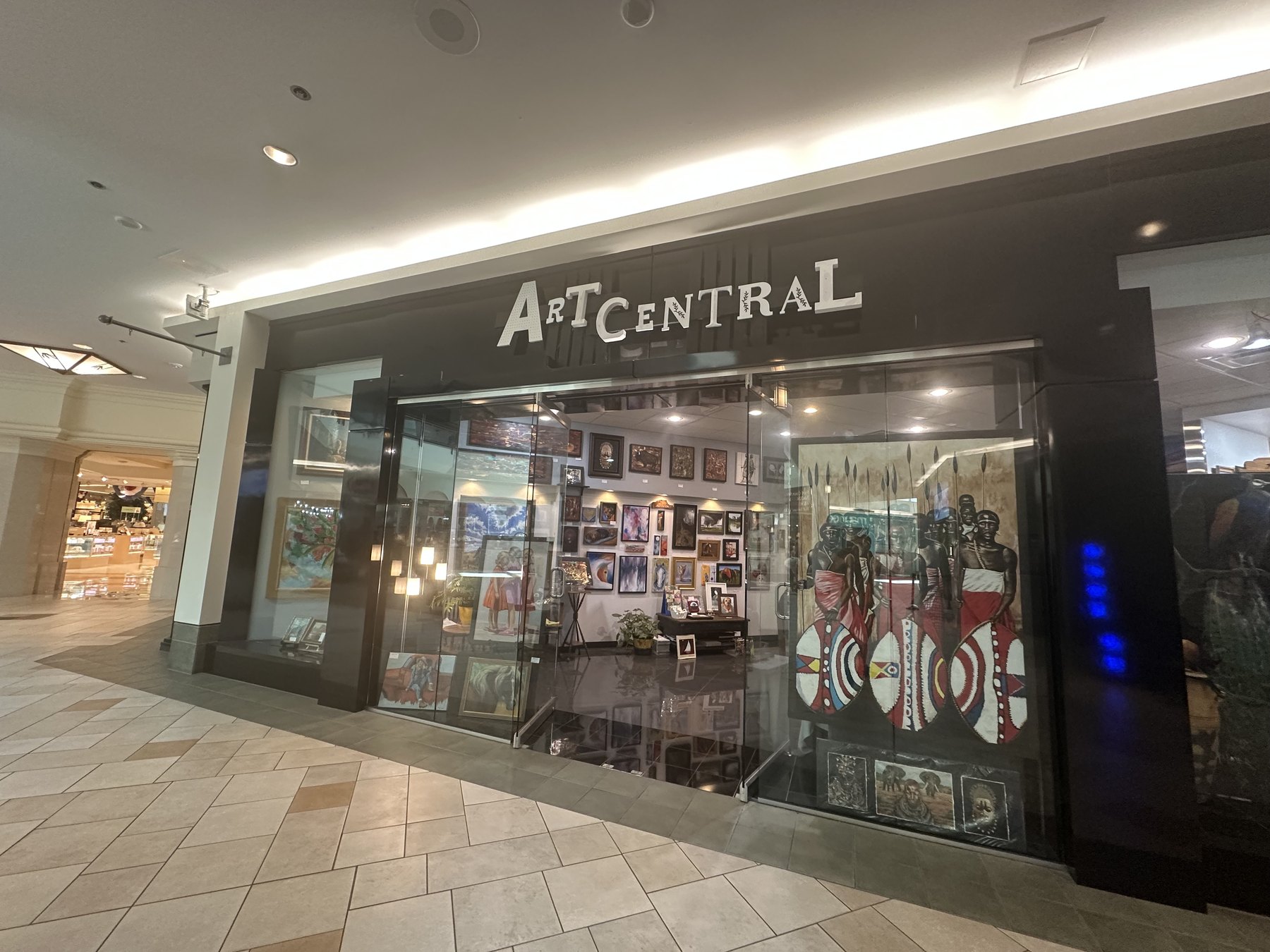 Art Central Gallery storefront inside Quail Springs Mall in Oklahoma City with artwork visible through the glass entrance
