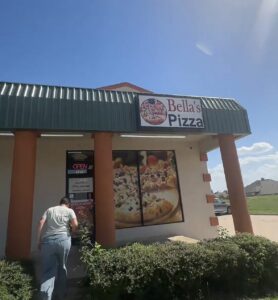 Exterior of Bella’s Pizza in Moore, Oklahoma, with the storefront sign above the entrance.