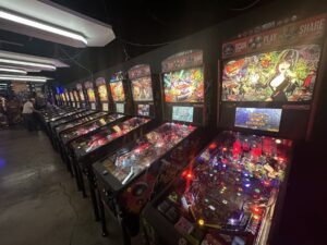 Row of colorful pinball machines glowing inside Cactus Jack’s Family Fun Center in Oklahoma City.