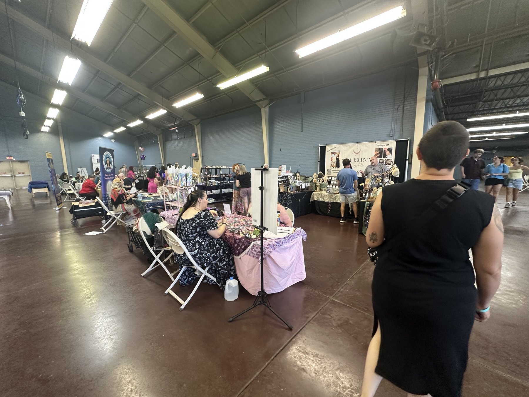 Wide view of vendor tables and visitors inside the Gypsy Soul Fair event hall in Oklahoma.