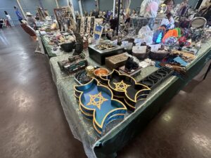 Colorful metaphysical vendor table with crystals, trays, jewelry, and spiritual goods at the Gypsy Soul Fair.