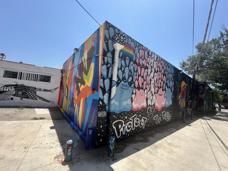 Colorful murals covering a corner building at Plaza Walls in Oklahoma City's Plaza District