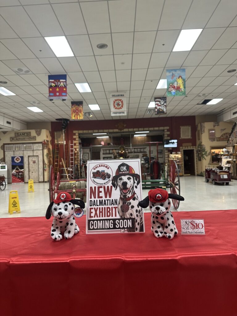 Dalmatian exhibit sign and plush fire dogs on a table inside the Oklahoma Firefighters Museum