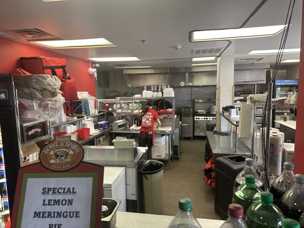 Kitchen and prep area at Hobby's Hoagies in downtown Oklahoma City with a lemon meringue pie special sign.