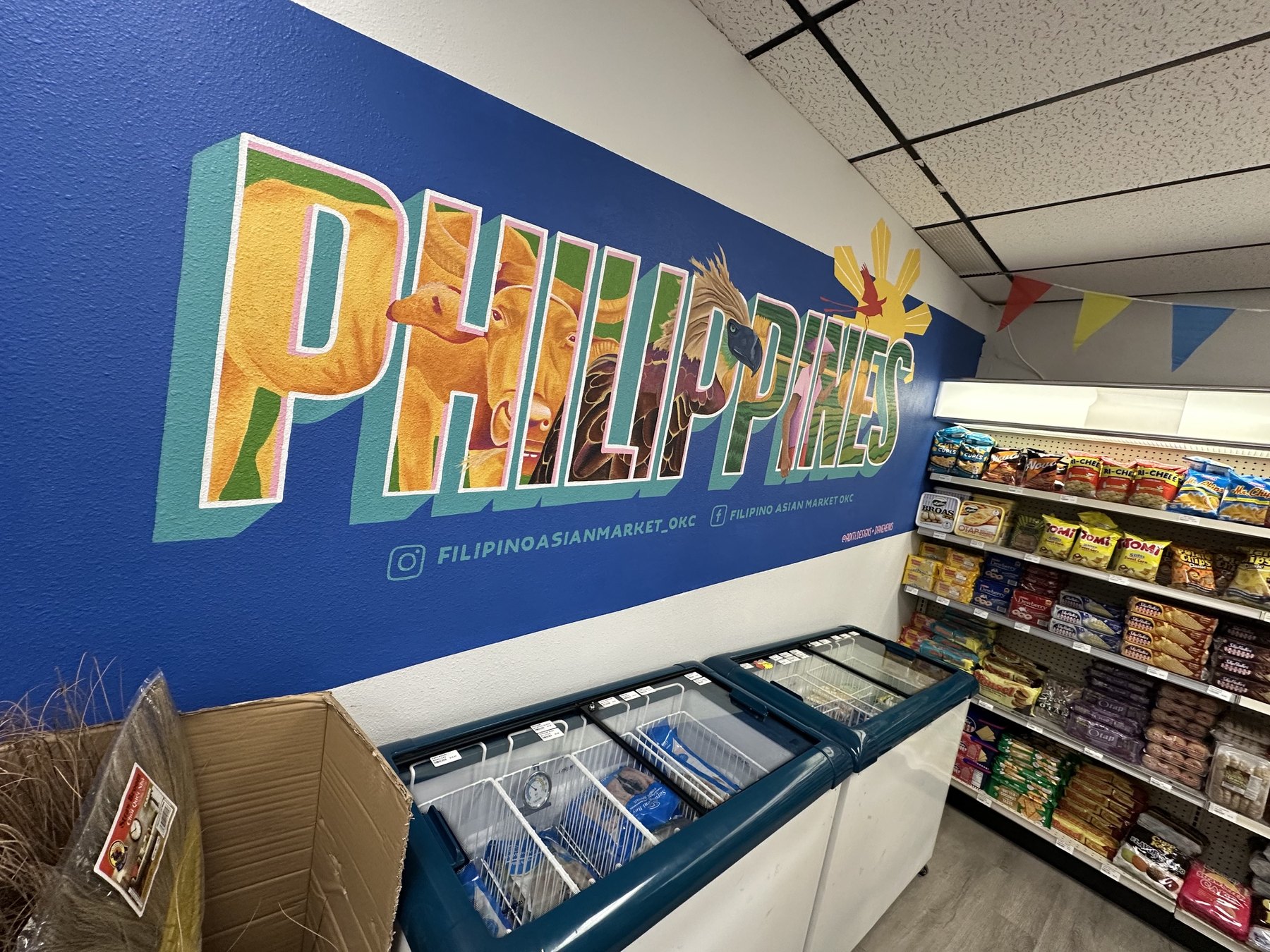 Colorful PHILIPPINES mural inside Filipino Asian Market in OKC above freezer cases and snack shelves.