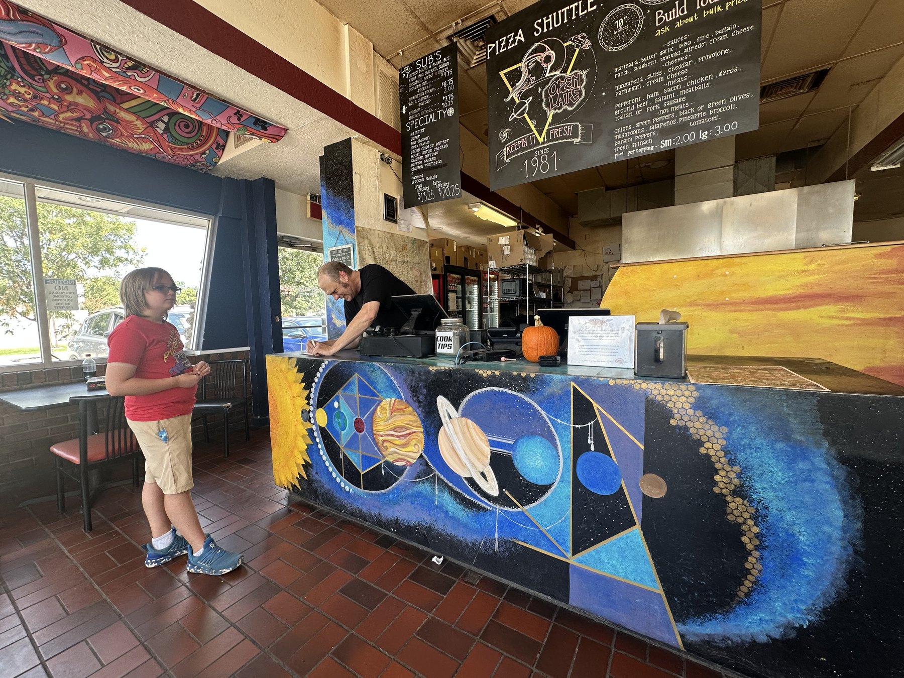 Interior counter and menu board at Pizza Shuttle in Norman, Oklahoma.