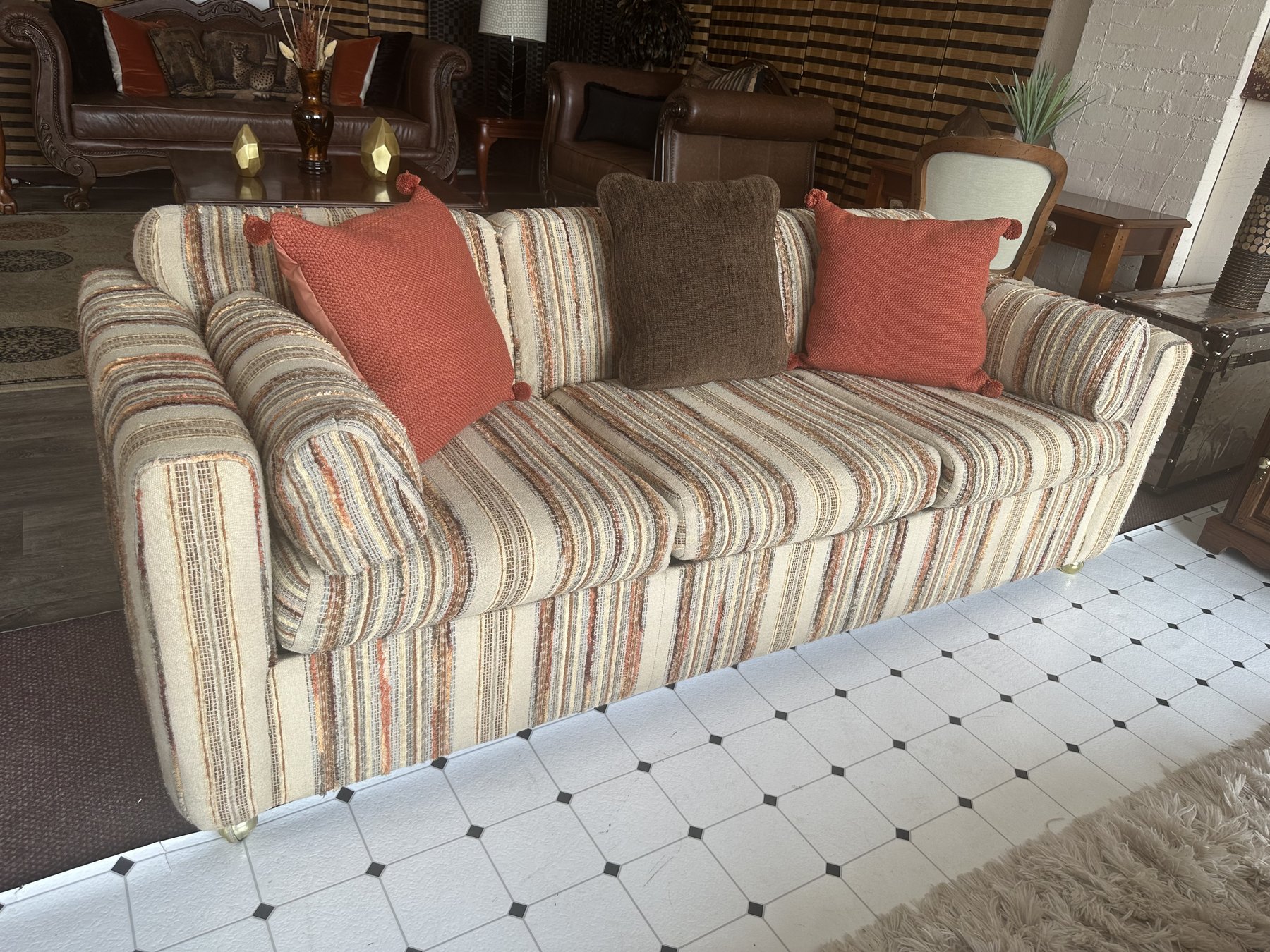 Striped sofa with orange and brown pillows on display inside Timeless Furniture's OKC showroom.
