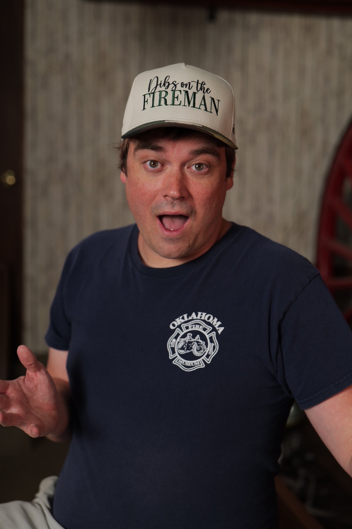 Participant in an Oklahoma Fire Museum shirt wears a hat that says Dibs on the Fireman.