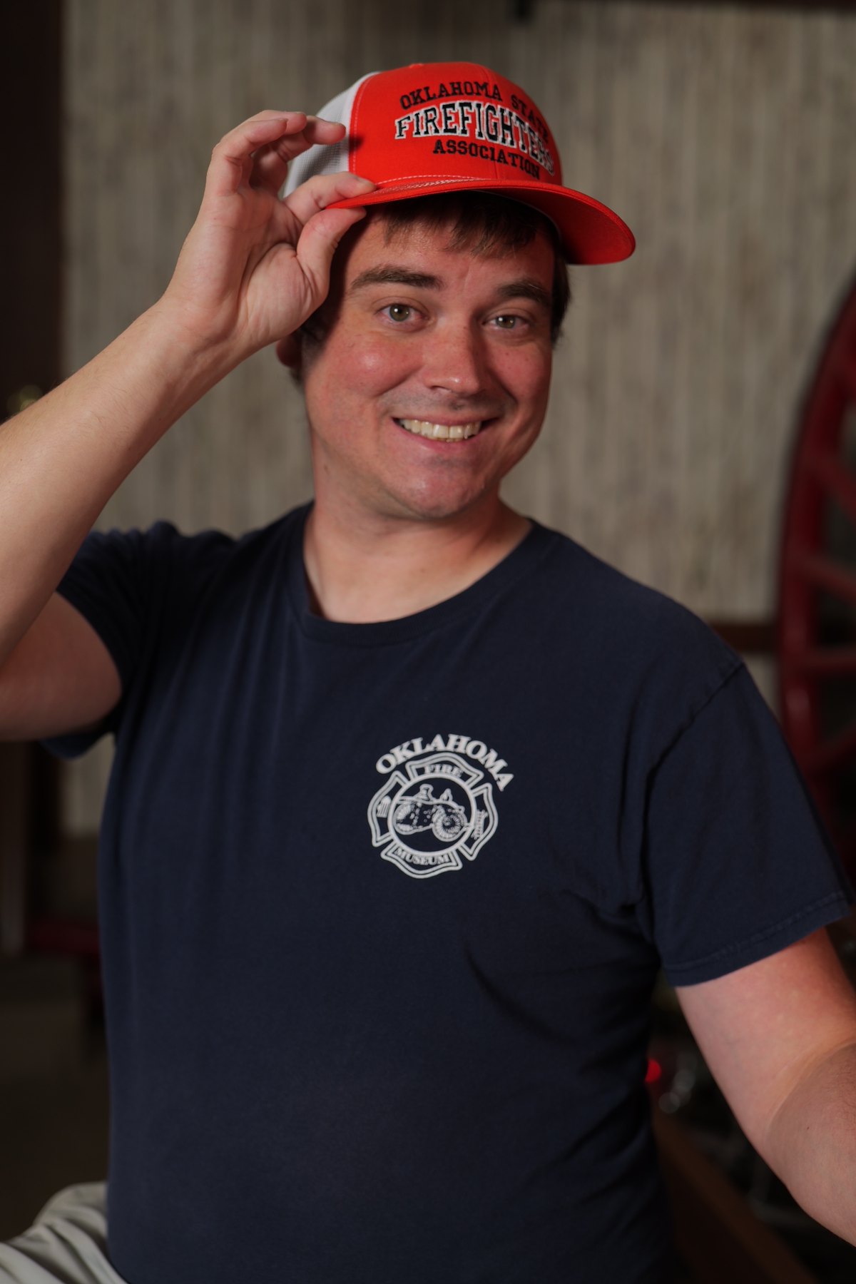Participant smiles while tipping an Oklahoma State Firefighters Association cap at the Oklahoma Fire Museum.