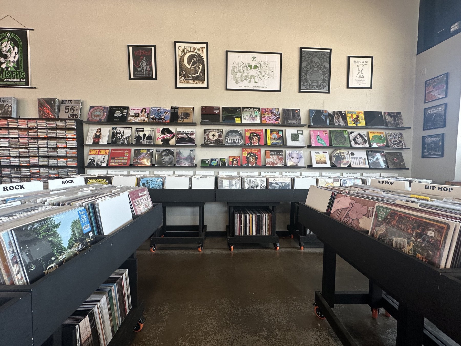 Wide interior view of vinyl bins, CDs, and wall displays at Guestroom Records Edmond.