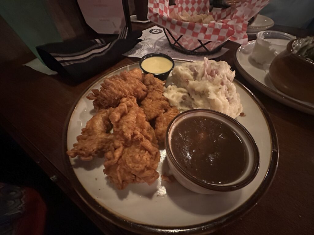 Fried chicken tenders with mashed potatoes, brown gravy, and dipping sauce at Hopscotch.
