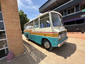 Vintage turquoise and cream bus parked beside Opolis in Midtown Oklahoma City.