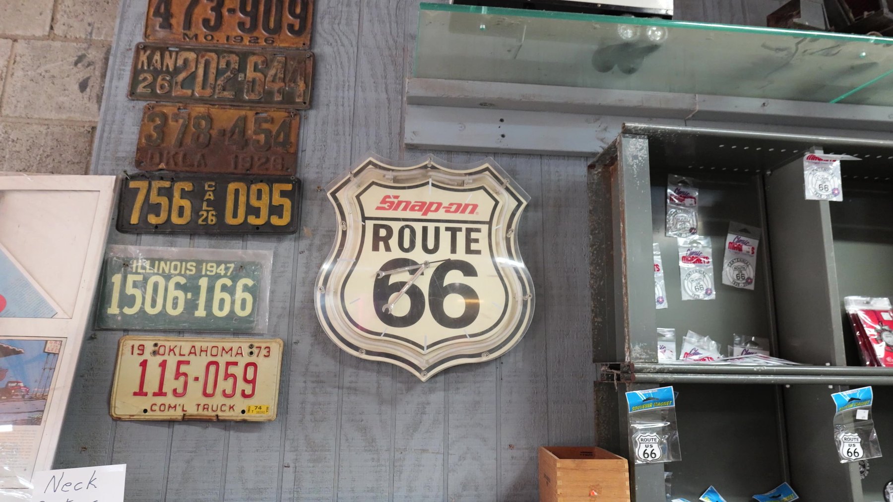 Route 66 sign, vintage license plates, and souvenirs displayed at Seaba Station Motorcycle Museum in Oklahoma.
