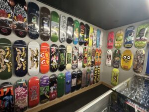 Colorful skateboard decks displayed on the wall inside Proper Skate Shop in Edmond.