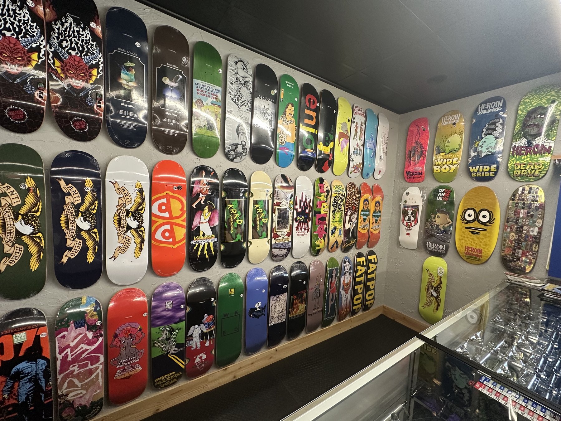Colorful skateboard decks displayed on the wall inside Proper Skate Shop in Edmond.