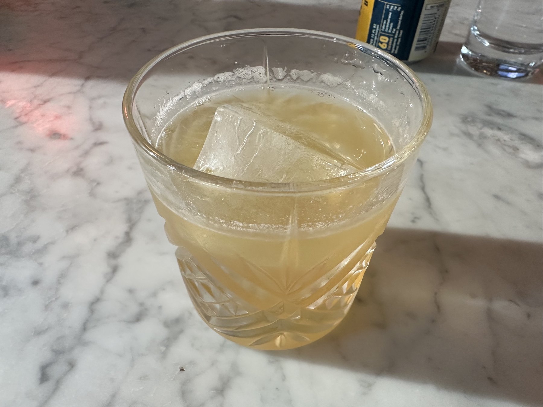 Cocktail served over a large ice cube on the marble bar at Red Rooster in Oklahoma City