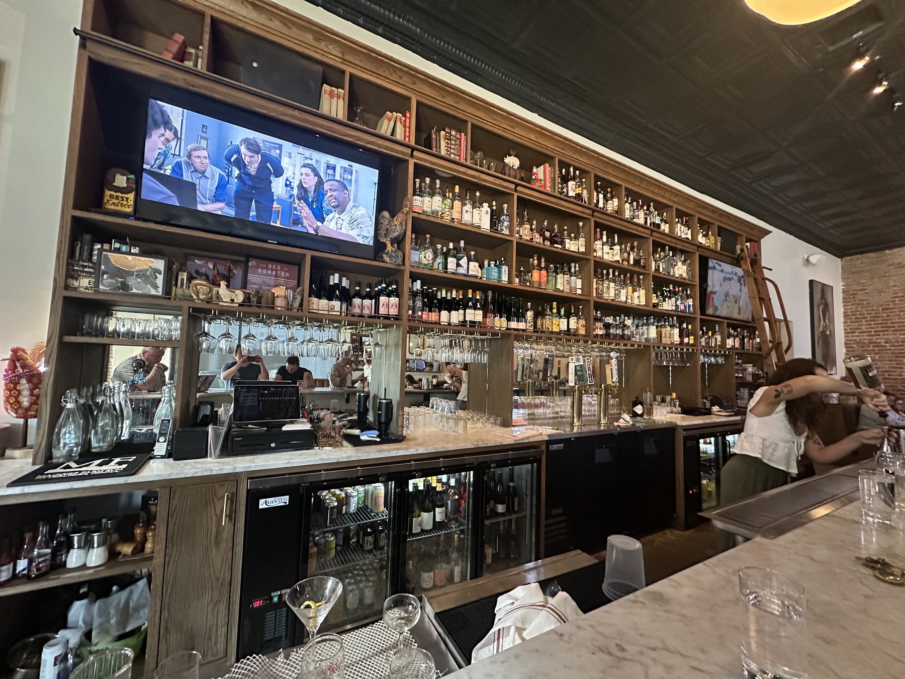 Tall bar shelves with bottles and glassware inside Red Rooster in Oklahoma City's Paseo District