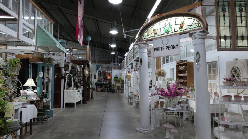 Wide interior aisle with vintage furniture and stained glass at The Rink Gallery in Bethany, Oklahoma.