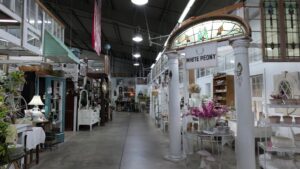 Wide interior aisle with vintage furniture and stained glass at The Rink Gallery in Bethany, Oklahoma.
