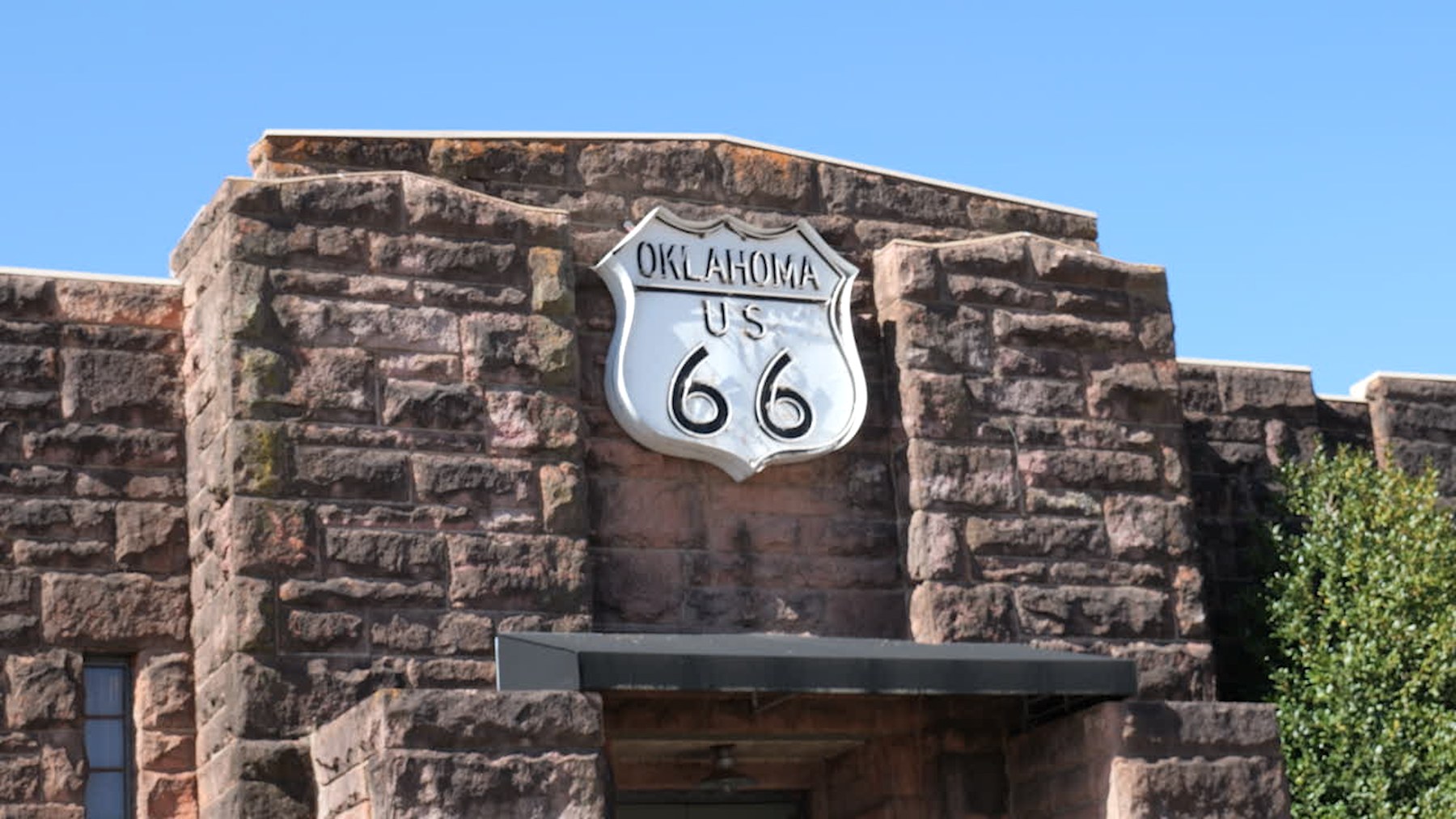 Stone entrance of the Route 66 Interpretive Center in Chandler with an Oklahoma Route 66 shield