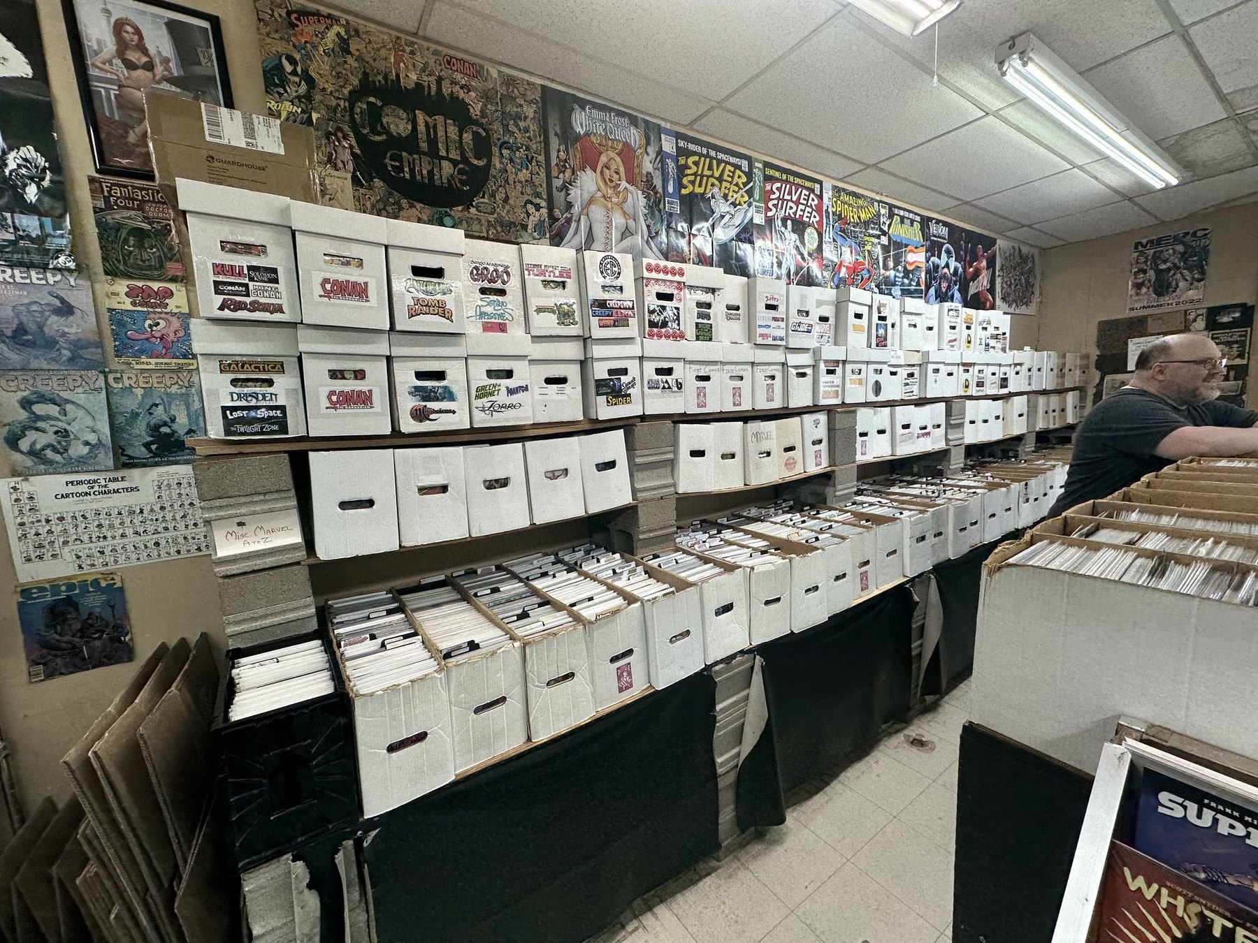 Shelves of white comic storage boxes and back issue bins at The Comic Empire