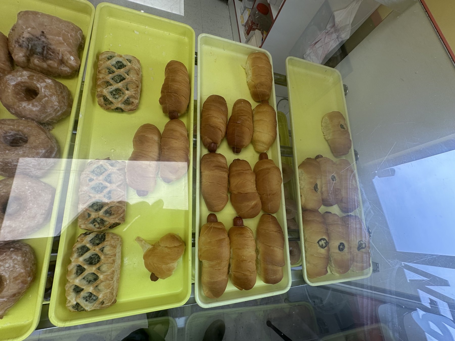 Kolaches, sausage rolls, and pastries in the Wow Donuts display case in Edmond