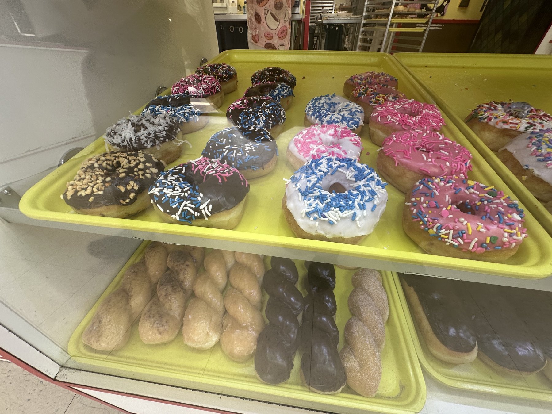 Colorful sprinkle donuts on a tray at Wow Donuts in Edmond