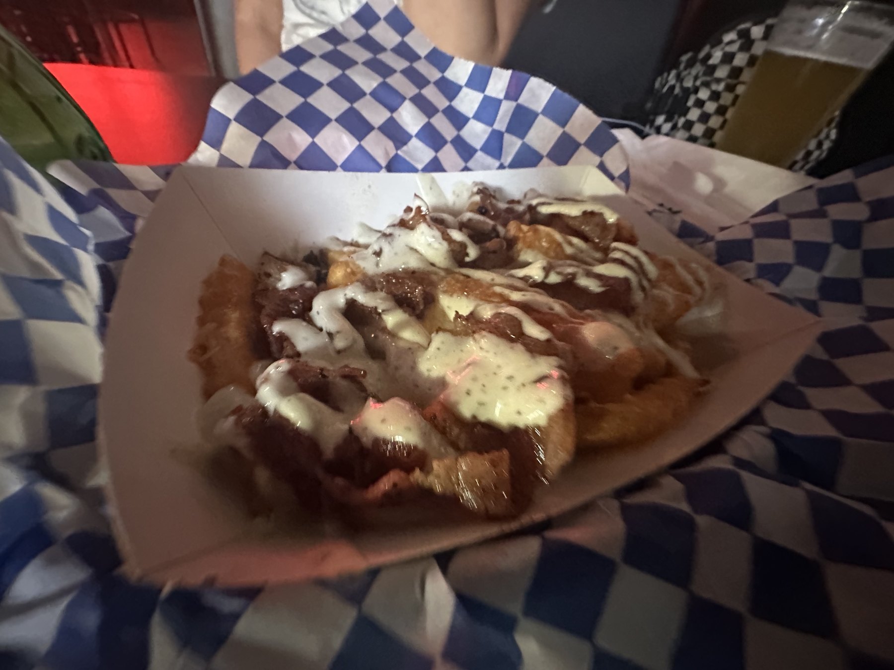 Loaded fries or nacho-style bar food at Rad Bar topped with meat, queso, and sauce.