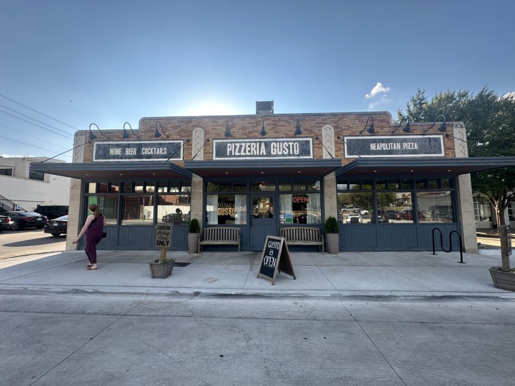 Exterior of Pizzeria Gusto in Oklahoma City with signs for Neapolitan pizza, wine, beer, and cocktails.