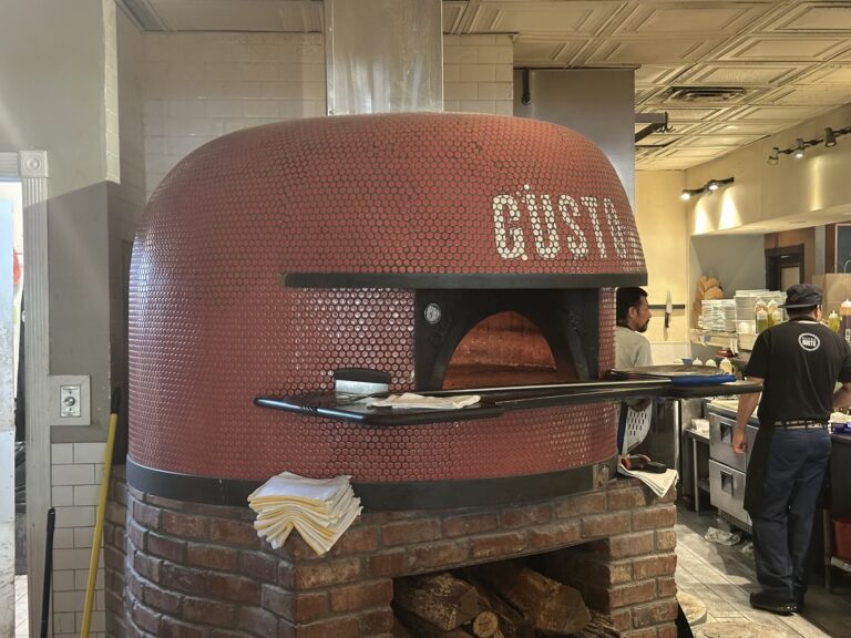 Large red wood-fired pizza oven inside Pizzeria Gusto in Oklahoma City.