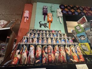 Novelty celebrity prayer candles displayed below colorful cat clocks inside Dig It in Oklahoma City.