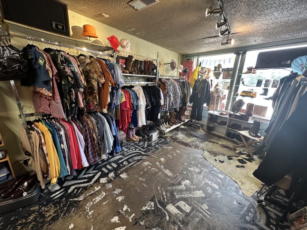Vintage clothing racks, boots, hats, and shoes inside Dig It in Oklahoma City.