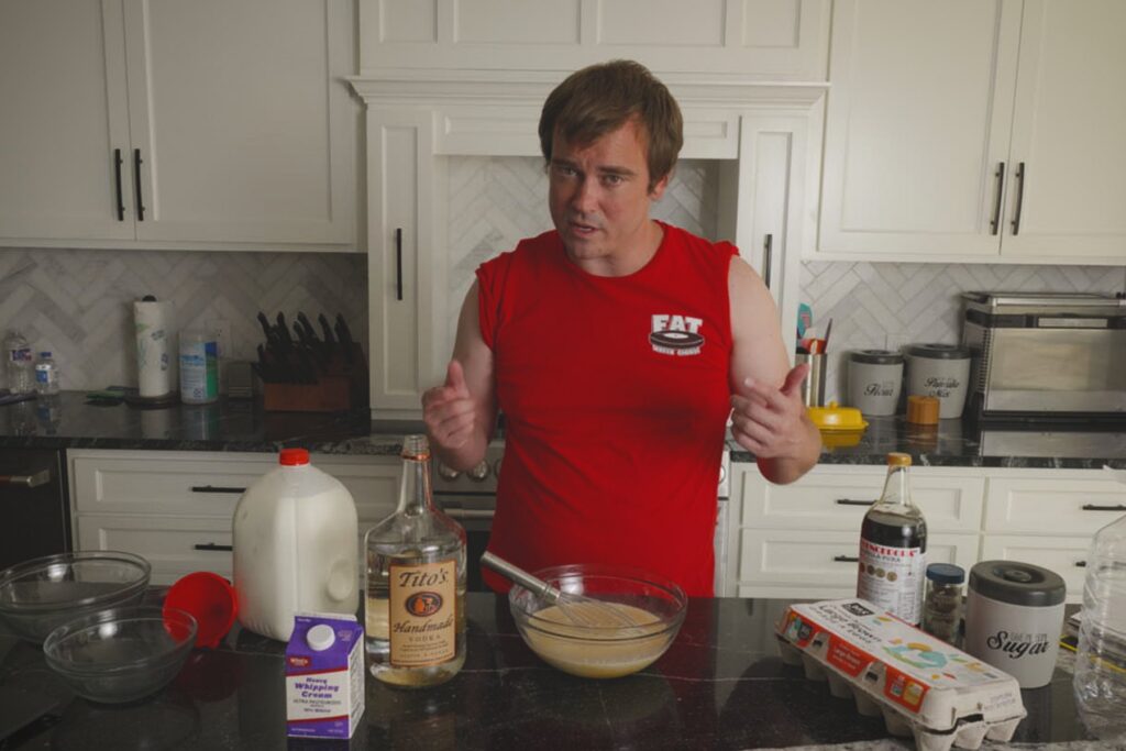Cook standing behind a glass bowl of mixed Fight Milk with ingredients on the kitchen counter.