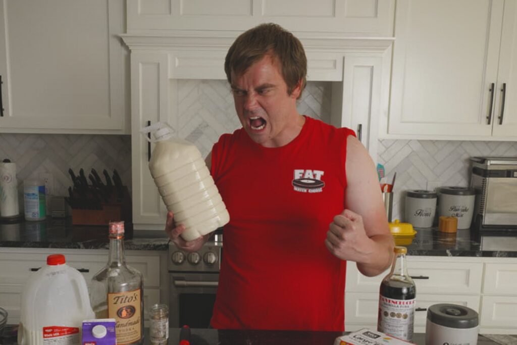 Cook yelling excitedly while holding a finished jug of homemade Fight Milk.