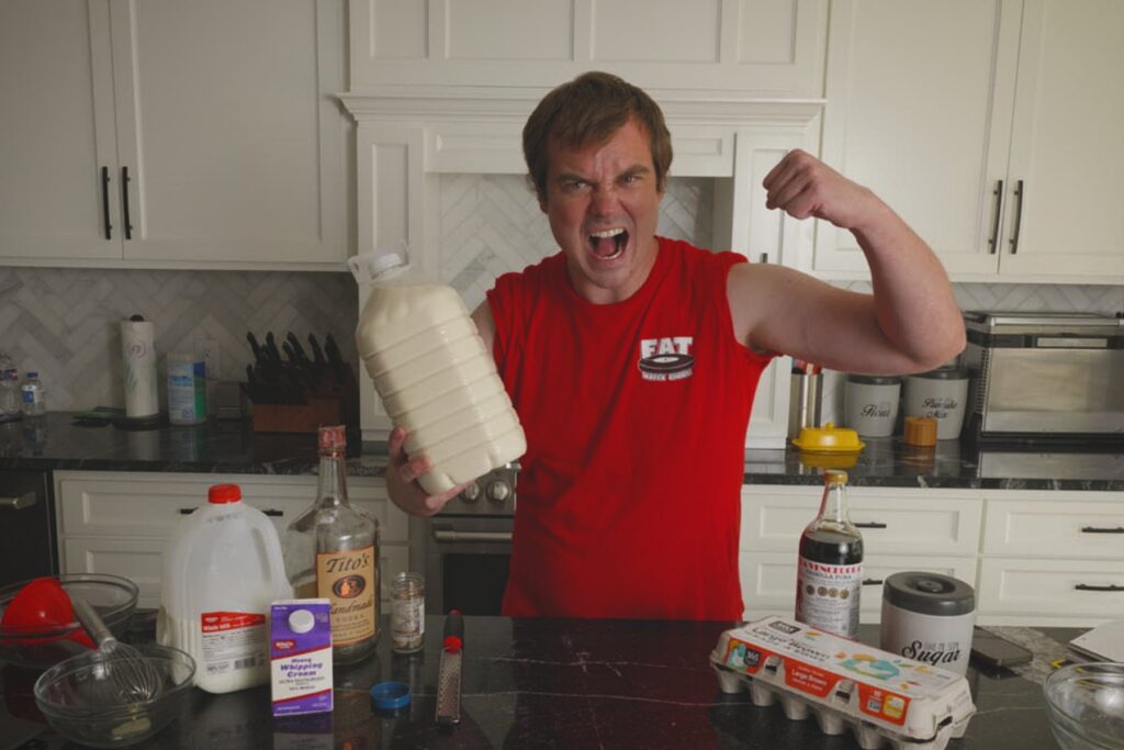 Cook flexing while holding a large finished jug of homemade Fight Milk.