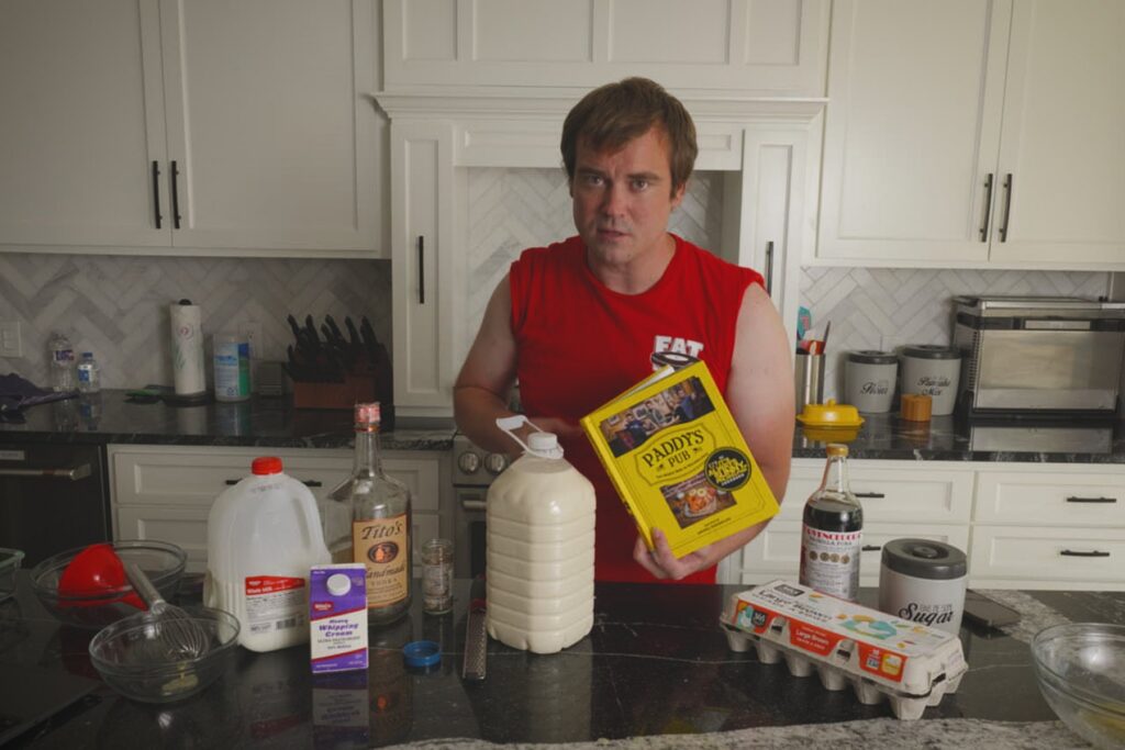 Cook holding the Paddy's Pub cookbook beside a finished jug of homemade Fight Milk.