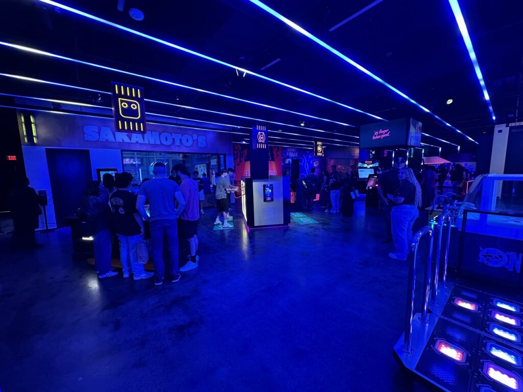 Blue-lit Netflix Bites Dallas experience area with guests, themed signs, and interactive displays