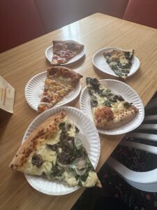 Assorted pizza slices on paper plates at Sauced on Paseo in Oklahoma City.