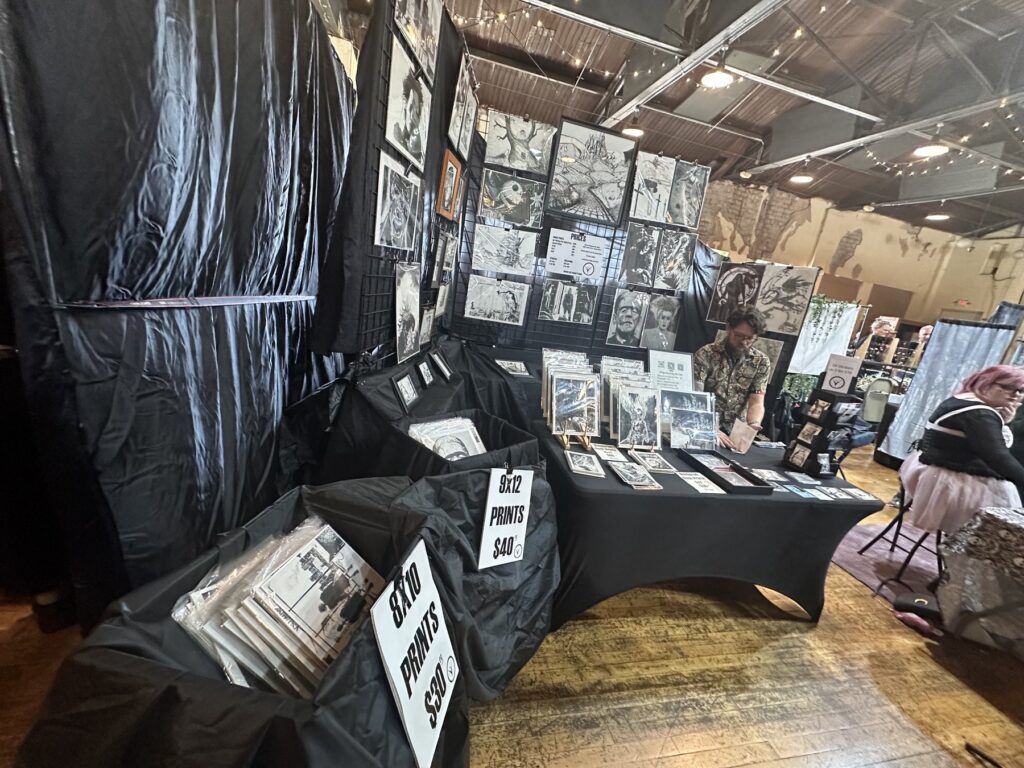 Black-and-white gothic art prints displayed at a vendor booth during the Gothic Market Festival in Oklahoma City.